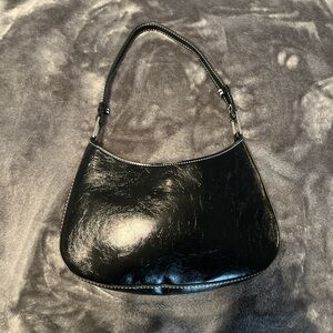 Urban outfitters black patent leather shoulder bag with silver accents.